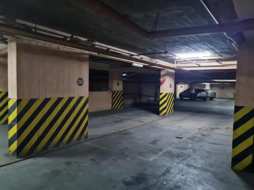 un garage vide avec des bandes jaunes et noires dans l'établissement Departamento completo 1D en Barrio Sur con cochera privada, à San Miguel de Tucumán