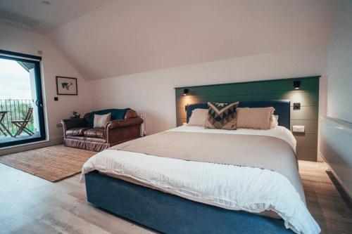 1 dormitorio con 1 cama grande y 1 silla en The Loft Studio apartment - above detached new build garage en Llanymynech