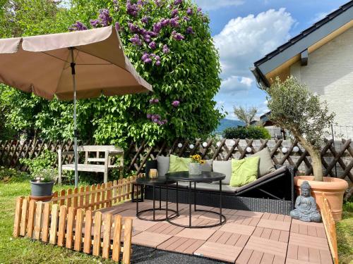 a patio with a table and an umbrella at Schwarzwaldliebe Ferienzimmer mit Bad in Gaggenau