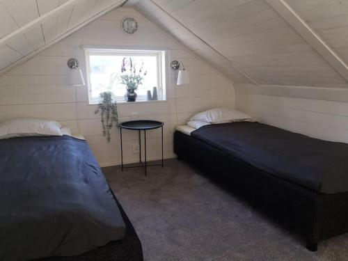 two beds in a room with a window and a table at Modern house on the countryside in lovely Bohuslän in Uddevalla