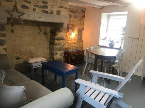 ein Wohnzimmer mit einem Sofa, einem Tisch und Stühlen in der Unterkunft Petite maison bretonne : P'ty Penty in Plougastel-Daoulas