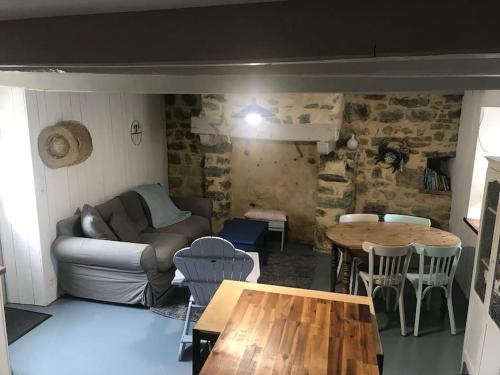 ein Wohnzimmer mit einem Sofa und einem Tisch in der Unterkunft Petite maison bretonne : P'ty Penty in Plougastel-Daoulas