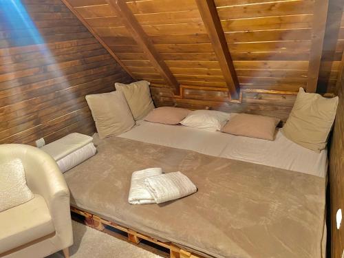 a bed in a small room with a couch in it at Zlatibor Sky Inn in Zlatibor