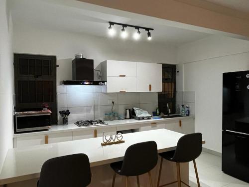 a kitchen with a white counter and black appliances at Les Olives in Flic-en-Flac