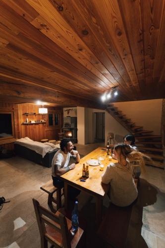 un groupe de personnes assises autour d'une table en bois dans l'établissement Chalet d'alpage Le Lauzeron, à Aiguilles