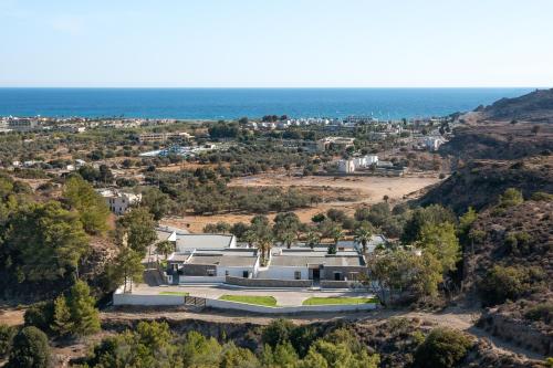 an aerial view of a building with the ocean in the background at Terra Pietra Luxury Villas & Suites in Lardos