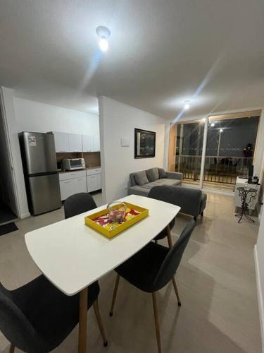 a kitchen and living room with a white table and chairs at Hermoso departamento con 3 dormitorios y estacionamiento in Puerto Montt