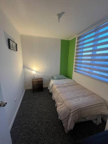 a bedroom with two beds and a window at Hermoso departamento con 3 dormitorios y estacionamiento in Puerto Montt