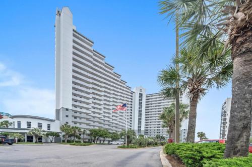 un gran edificio blanco con una bandera americana delante en Pelican Beach Resort Unit 1109, en Destin