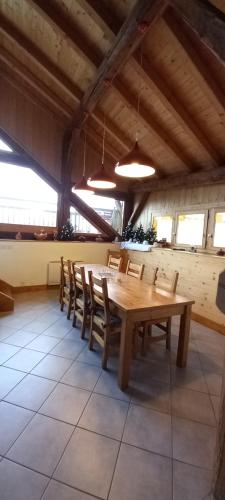 une salle à manger avec une table et des chaises en bois dans l'établissement Les balcons de Montvilliers, à Aime La Plagne