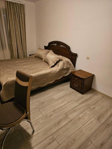 a bedroom with a bed and a chair and a table at Квартира отдыха in Ijevan