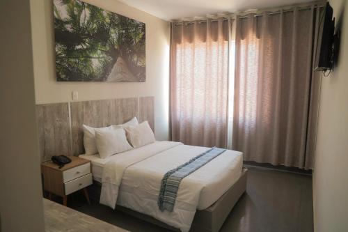 um pequeno quarto com uma cama e uma janela em Slim HOTEL em Piura