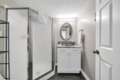 a white bathroom with a sink and a mirror at Pelican Beach Resort Unit 1109 in Destin