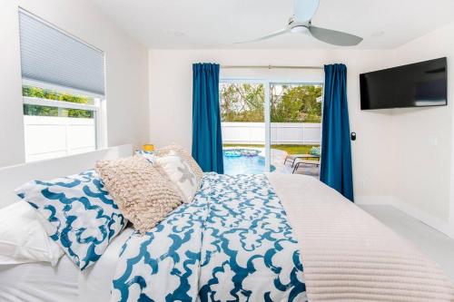 a bedroom with a large bed with blue and white sheets at Seahorse Cottage - Pool Home in Naples