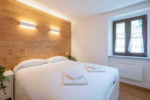 a bedroom with a large white bed with towels on it at [IHost Luxury Flat Bormio] - Centrale 69 in Piatta