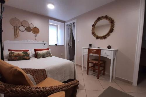 sypialnia z łóżkiem, stołem i lustrem w obiekcie Casa de Carolina. w mieście A Coruña