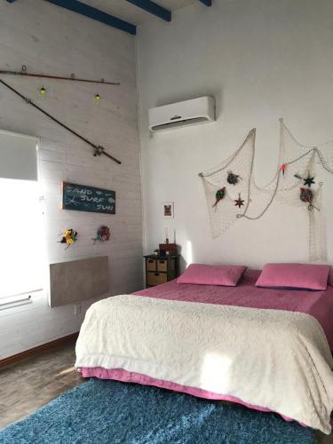 a bedroom with a bed with pink pillows and a window at Itaca delta cabañas in Tigre