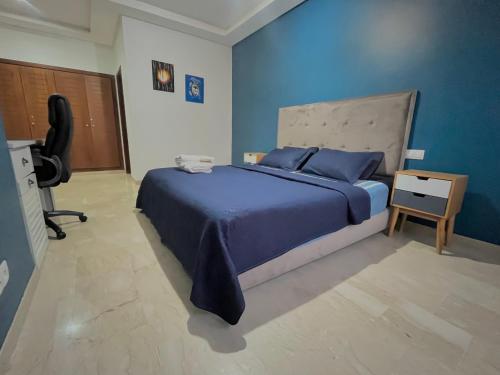 una camera blu con letto e scrivania di Luxury résidence Taj Nouaceur a Nouaseur
