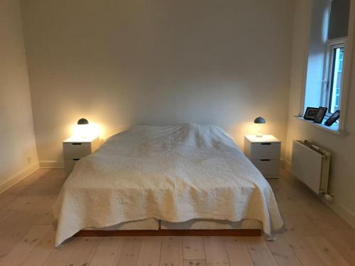 a bedroom with two nightstands and a bed with two lights at Vidunderligt byhus, 180m2 i hjertet af Esbjerg. in Esbjerg