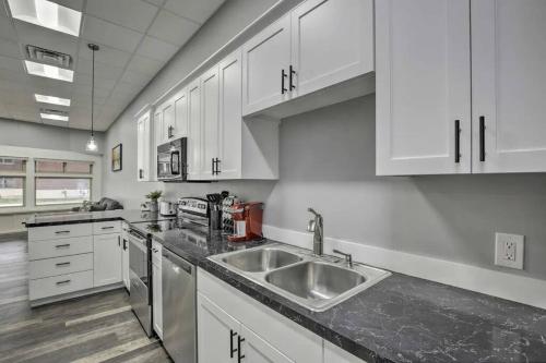 a kitchen with white cabinets and a stainless steel sink at The Pad-Spacious King apartment on main level in Albert Lea