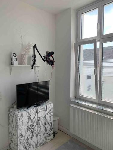 a room with a flat screen tv sitting on a box in front of a window at Zentrale Wohnung in Dortmund in Dortmund