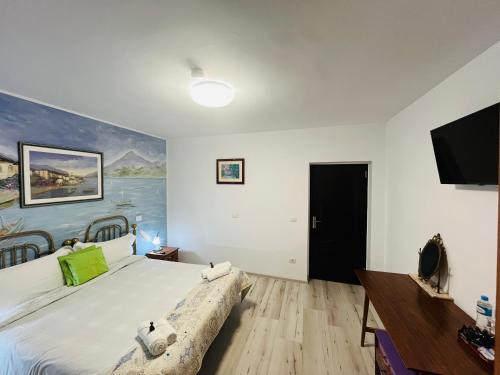 a bedroom with a large bed and a flat screen tv at CASA MATILI-1st floor of the house in Piatra Neamţ