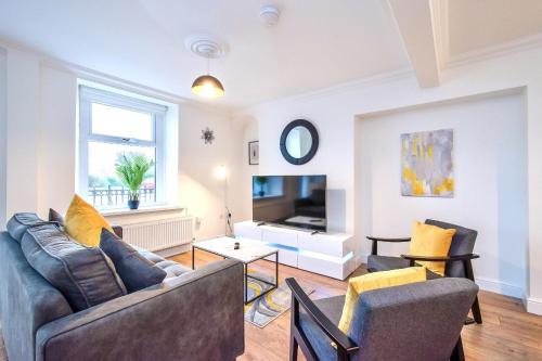 a living room with a couch and a table at Casa One Hundred - A Beautiful 4 Bed House on the Beach Front in Swansea