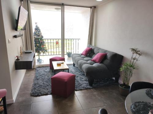 a living room with a couch and a christmas tree at Hermoso departamento in Coquimbo