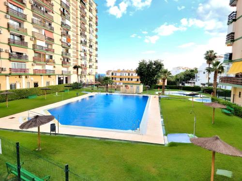una piscina in un parco di fronte a un edificio di Estudio Las Naciones Bellavista a Benalmádena