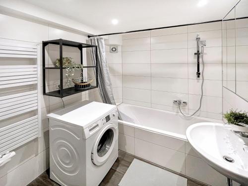 a white bathroom with a washing machine and a sink at Gemütliche Oase in der Innenstadt, zwei Minuten zum Rathaus in Augsburg