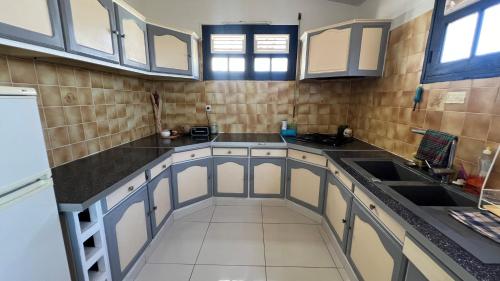 a kitchen with white cabinets and black counter tops at Le Ray Mundo F5 in Le Vauclin