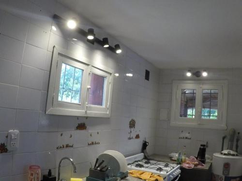 a kitchen with a stove and two windows in it at San Miguel del monte 6 personas con pileta in San Miguel del Monte