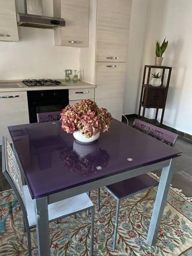 uma mesa roxa com um vaso de flores na cozinha em 731 Reasons For Back em Cerea