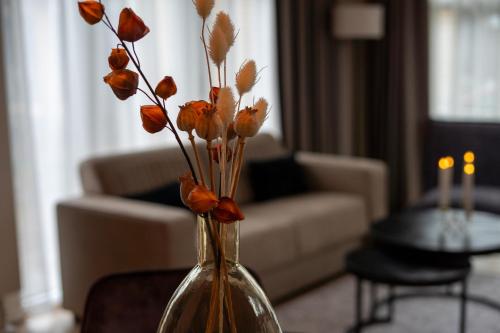 a vase with orange flowers in a living room at Huisje Novea in Harderwijk