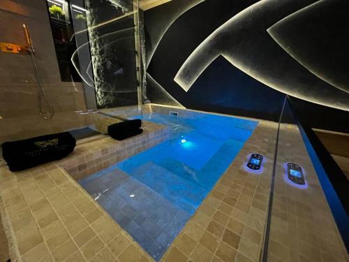 a swimming pool in a room with a shower at Les Secrets Rooms/Love Room in Rivesaltes