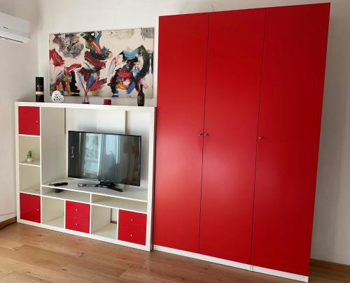 a living room with red cabinets and a tv at White Love Versilia in Viareggio