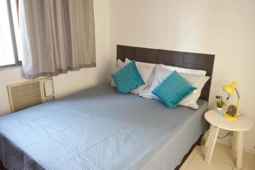een bed met blauwe en witte kussens in een slaapkamer bij Ap centro Convenções 3Q in Salvador