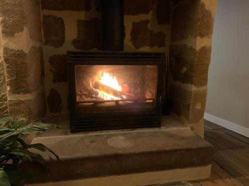 a brick fireplace with a fire in it at appartement de charme centre historique de Brive in Brive-la-Gaillarde