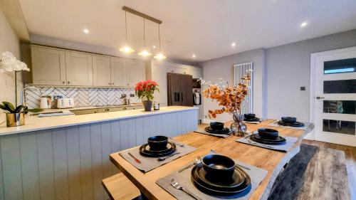 a kitchen with two wooden tables with black dishes on it at The 4-Bed Brighton Escape in Brighton & Hove