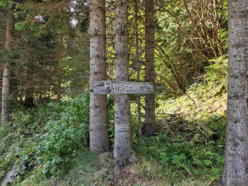 a sign in the middle of a forest at Fleissner Hütte in Innerkrems