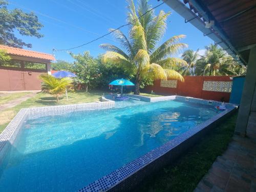 a swimming pool in a yard with a palm tree at Casa para descanso familiar in San Pedro Masahuat