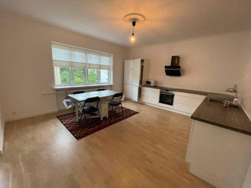 una sala de estar vacía con mesa y cocina en Spacious room in shared accommodation, en Gentofte