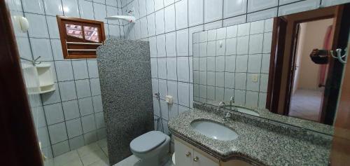 een badkamer met een wastafel en een toilet bij Casa Temporada Guriri Beach in Guriri