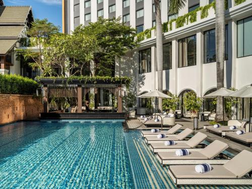 a swimming pool with lounge chairs and a building at InterContinental Chiang Mai The Mae Ping in Chiang Mai