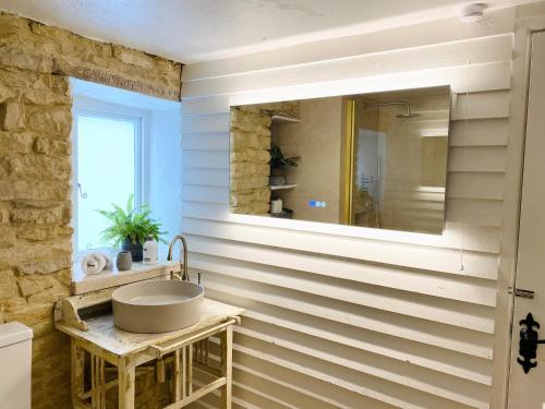 a bathroom with a sink and a mirror at Charming Cottage in Heart of Bourton-on-the Water in Bourton on the Water
