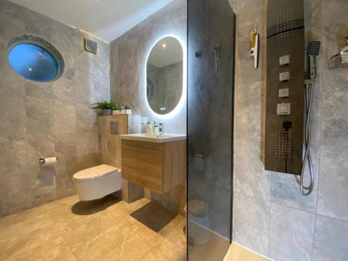 a bathroom with a toilet and a sink and a mirror at Lake District cottage in 1 acre gardens off M6 in Penrith