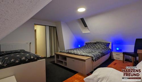 a bedroom with two beds and blue lights at Arode Grosser Harzensfreund in Sankt Andreasberg