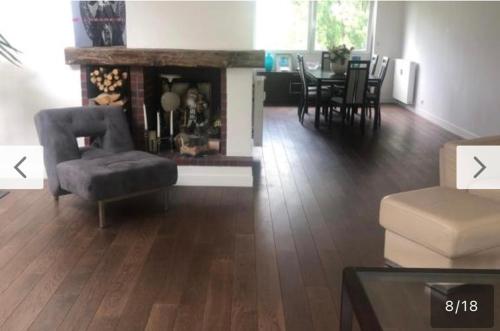 - un salon avec une cheminée, une chaise et une table dans l'établissement Chambre à louer dans un panthause, à Bourg-la-Reine