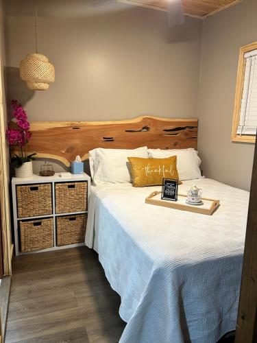 a bedroom with a large bed with a wooden headboard at Sweet Tiny Cabin in Tampa