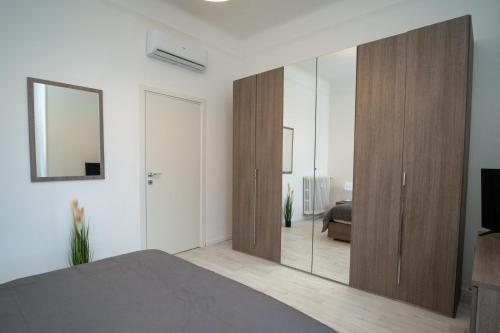 a bedroom with a large wooden closet with a mirror at AG apartment in Cormano